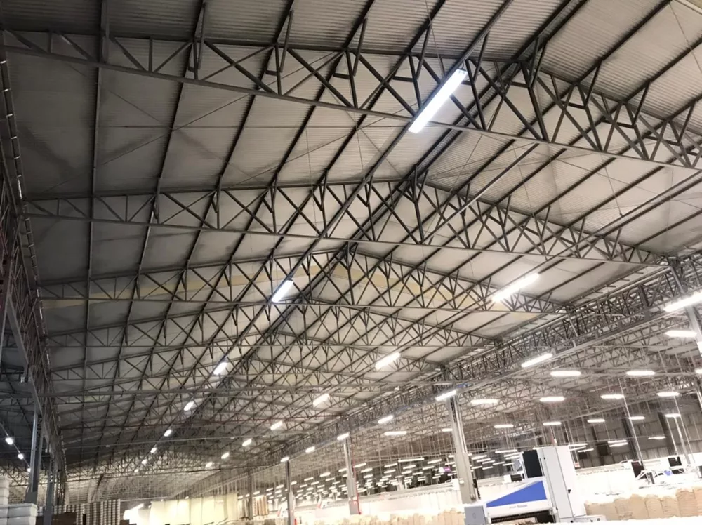 Vista interna das tesouras metálicas de um complexo industrial de 30.600 m² durante o diagnóstico estrutural